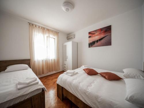 Un dormitorio con dos camas y una ventana. en Apartment in Seline near Paklenica Park, en Seline