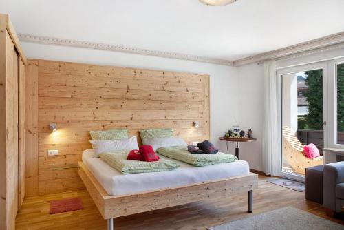 Bett in einem Zimmer mit einer Holzwand in der Unterkunft Berghex in Garmisch-Partenkirchen