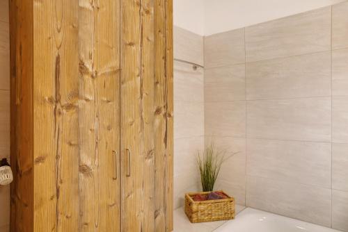 een badkamer met een houten douchecabine en een bad bij Berghex in Garmisch-Partenkirchen