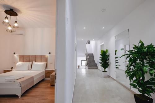 a bedroom with a bed and a hallway with plants at Venti et Maris in Ksamil