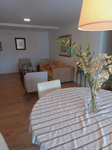 una sala de estar con una mesa con un jarrón de flores. en 867Salta en Salta