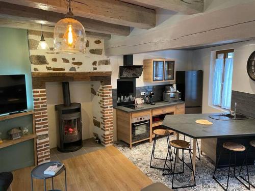 Voutezac的住宿－Maison de village avec vue 4/5 personnes Lou Rouchou，厨房配有壁炉和桌椅。