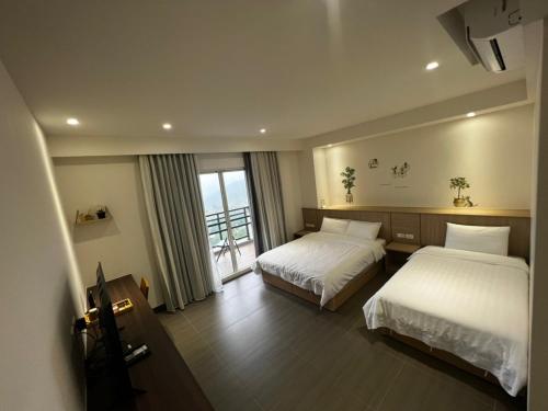 Hung-pi-shou的住宿－一卷石民宿，酒店客房设有两张床和窗户。