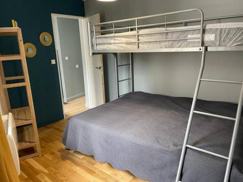 ein Schlafzimmer mit einem Etagenbett und ein Zimmer mit einer Leiter in der Unterkunft Maison de village avec vue 4/5 personnes Lou Rouchou in Voutezac
