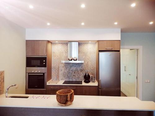 una cucina con lavandino e frigorifero di Exclusivo Apartamento a 500 metros de la Playa a Castelldefels