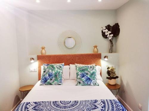 una camera da letto con un letto con cuscini blu e bianchi di Exclusivo Apartamento a 500 metros de la Playa a Castelldefels