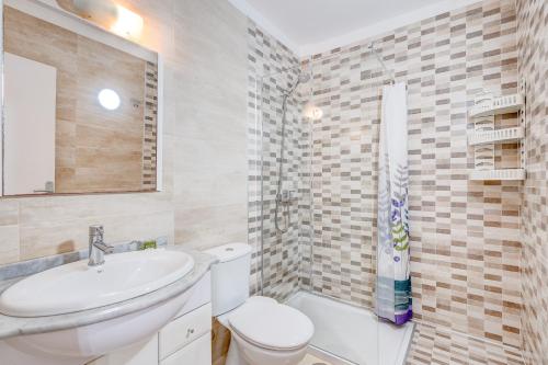 W łazience znajduje się umywalka, toaleta i lustro. w obiekcie Parque Royal 1A255 w Adeje