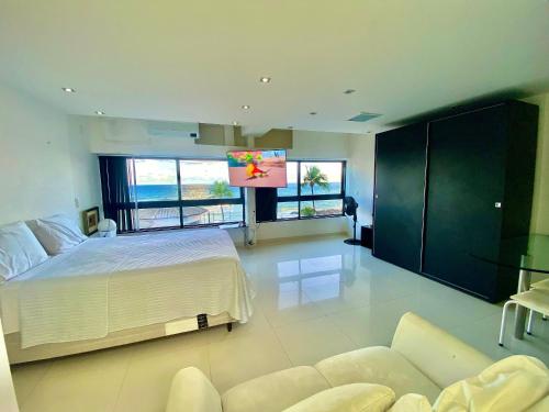 a bedroom with a large bed and a large screen at Ondina Apart Hotel Residences in Salvador