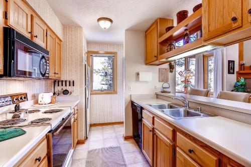 a kitchen with wooden cabinets and a sink at Evergreen Condominiums by Keystone Resort in Keystone
