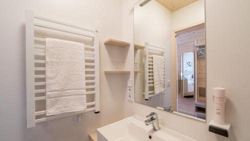 ein weißes Badezimmer mit einem Waschbecken und einem Spiegel in der Unterkunft freilich. Bistro. Bar. Hotel - digitaler self check in in Laa an der Thaya