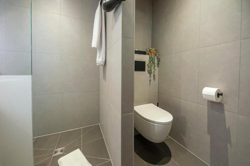 a bathroom with a toilet and a toilet paper dispenser at LOGINN Hotel Waiblingen in Waiblingen