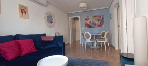 een woonkamer met een blauwe bank en een tafel bij Karina Apartaments in Torrevieja