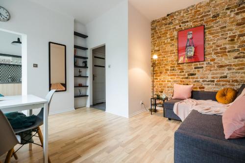 a living room with a brick wall and a couch at ShortStayPoland Joteyki (B125) in Warsaw
