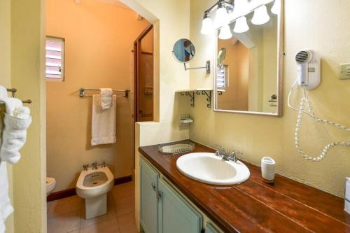 uma casa de banho com um lavatório e um WC em Villa Ordnance em English Harbour Town