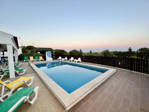 a swimming pool with lounge chairs and a swimming poolvisor at Tavira Vila Formosa 3 With Pool by Homing in Tavira