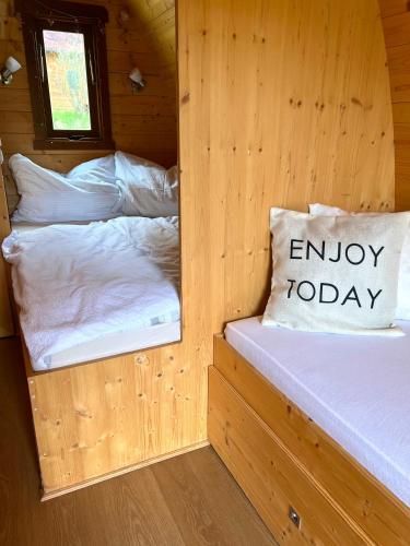 two beds in a wooden cabin with a window at Gold Camping Seeboden in Seeboden