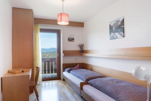 a bedroom with two beds and a balcony at Apartment Rosengartenblick in Steinegg
