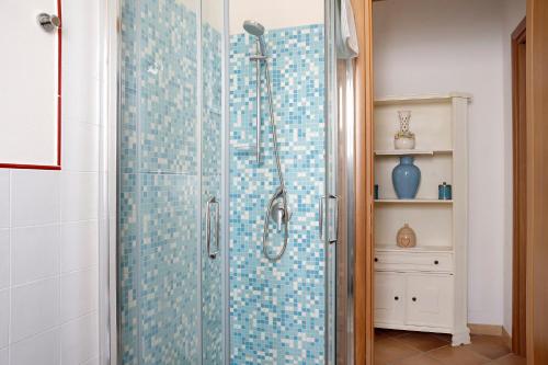 uma casa de banho com chuveiro e azulejos azuis na parede em La Corte di Langa alloggio Rubino em Albaretto Della Torre 