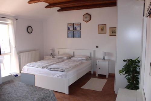 sypialnia z dużym białym łóżkiem w pokoju w obiekcie Rooms and Apartments Robert w Rovinj