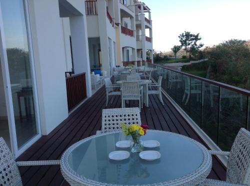 a glass table on a balcony with chairs and tables at Mansiones Cruz del Mar Huatulco in Santa Cruz Huatulco