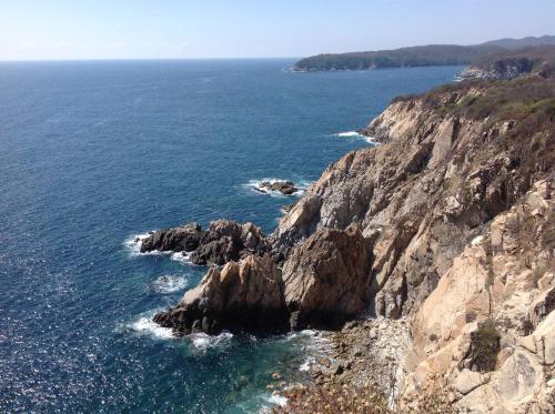 an aerial view of a rocky coastline with the ocean at Mansiones Cruz del Mar Huatulco in Santa Cruz Huatulco