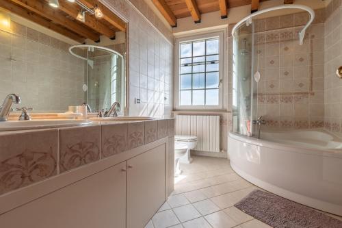 y baño con bañera, lavabo y aseo. en Italian Experience-Glicine Holiday Apartment, en Castello Ripalta