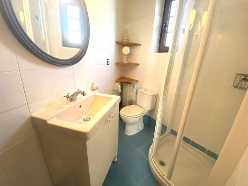 a bathroom with a sink and a toilet and a mirror at Casuca El Trisquel - 18002 in Bareyo