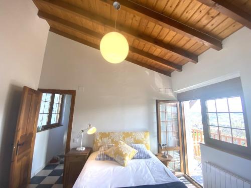 a bedroom with a bed and a lamp and windows at Casuca El Trisquel - 18002 in Bareyo
