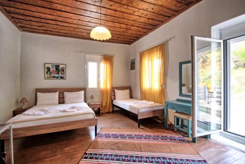 1 dormitorio con 2 camas y ventana en Aretousa by PosarelliVillas, en Dhrakóna