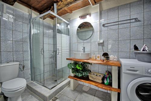 y baño con ducha, aseo y lavamanos. en Aretousa by PosarelliVillas en Dhrakóna