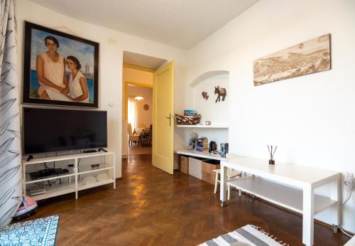 a living room with a flat screen tv and a table at Apartment Julietta in Rab