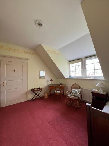 an attic room with a white door and a red carpet at Schloss Rössing - Messezimmer in historischem Ambiente in Nordstemmen