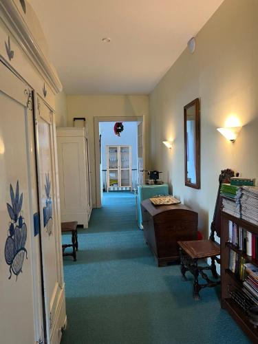 a living room with a hallway with a table and a chair at Schloss Rössing - Messezimmer in historischem Ambiente in Nordstemmen