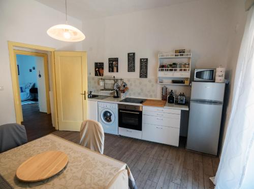 eine Küche mit weißen Geräten, einem Tisch und einem Esszimmer in der Unterkunft Apartment Julietta in Rab
