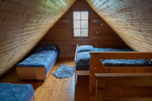 pokój z 2 łóżkami w drewnianym domku w obiekcie Domki nad jeziorem-Wodnik w mieście Zarzecze