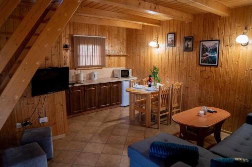 kuchnia i salon w drewnianym domku w obiekcie Domki nad jeziorem-Wodnik w mieście Zarzecze