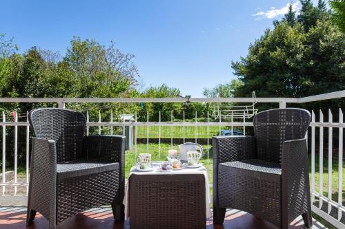 2 sedie in vimini e un tavolo su un patio di Malpensa Garden a Case Nuove