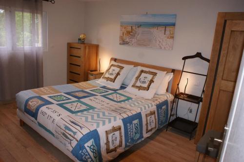 una camera con un letto con una trapunta blu e bianca di La Kerandière a Tonquédec