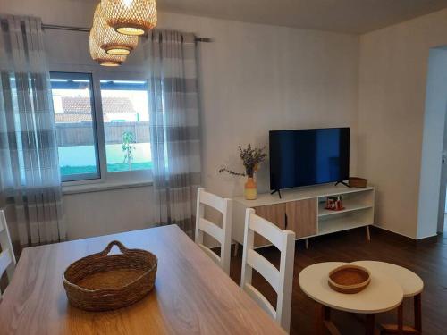 a living room with a table and a television at Sado House 2 in Comporta