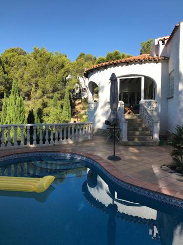 una piscina frente a una villa con una casa en El Paradiso, en Altea