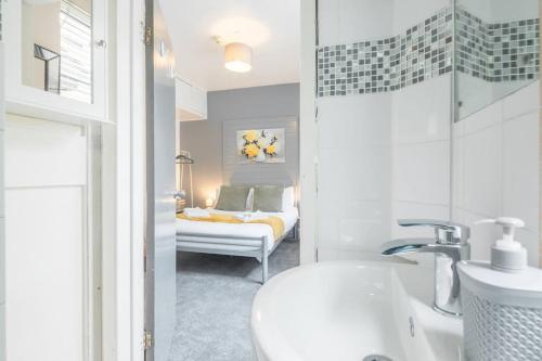 a bathroom with a sink and a bedroom with a bed at Milton House Private Room 2 in Cambridge - Perfect for Contractors and Solo Traveler in Chesterton