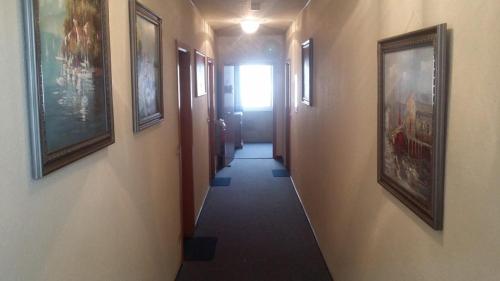 a hallway with paintings on the walls and a hallway with a hallwayngthngthngth at Schwäbischer Hof in Markgröningen