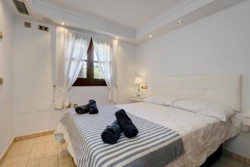ein Schlafzimmer mit einem Bett mit zwei schwarzen Schuhen darauf in der Unterkunft Casa Marie in Estepona