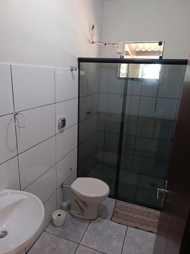 a bathroom with a toilet and a glass shower at Casa Ana in Dourados