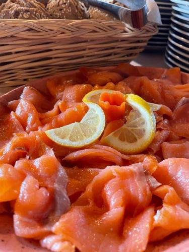 a plate of food with salmon and lemon slices at Pension Dolomieu in Santa Cristina in Val Gardena