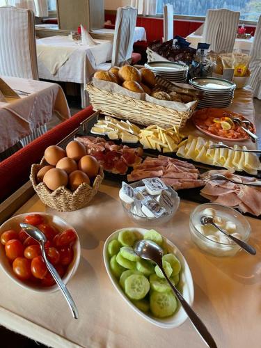 a table with plates of food and bowls of food at Pension Dolomieu in Santa Cristina in Val Gardena