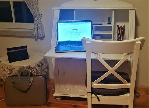 a laptop computer sitting on a desk with a chair at Podlaski Zakątek in Bereżyszcze