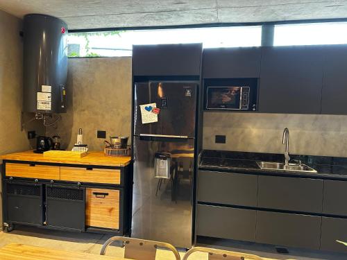 a kitchen with a stainless steel refrigerator and a sink at Loft 1930 in Villa Carlos Paz