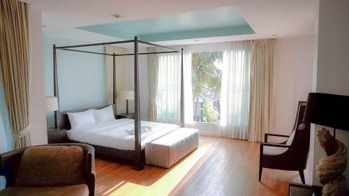 a bedroom with a bed and a large window at Nirvana Hua Hin Pool Villa in Phetchaburi