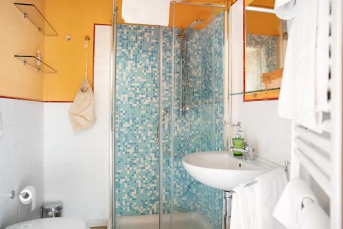 ein Bad mit einem Waschbecken und einer Glasdusche in der Unterkunft La Corte di Langa alloggio Quarzo in Albaretto Della Torre 